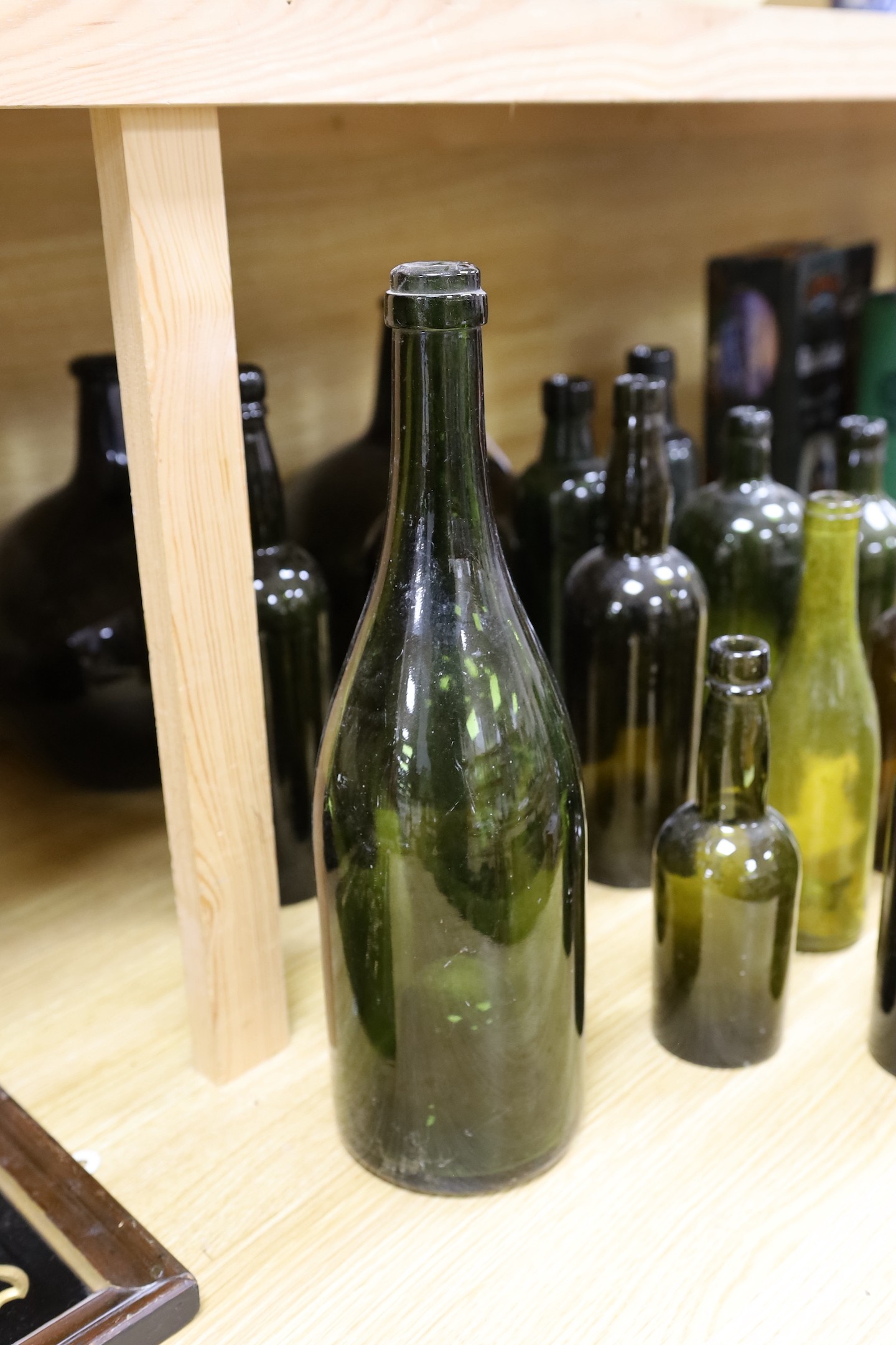 A pair of 18th century green glass onion bottles and a large quantity of other green glass bottles, tallest 38cm